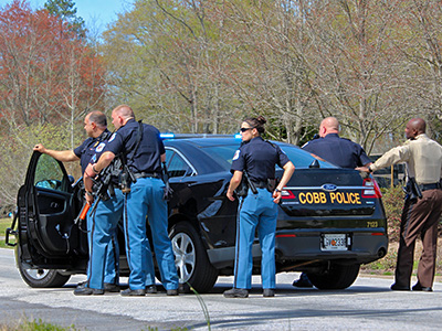 police officers gathered around patrol car